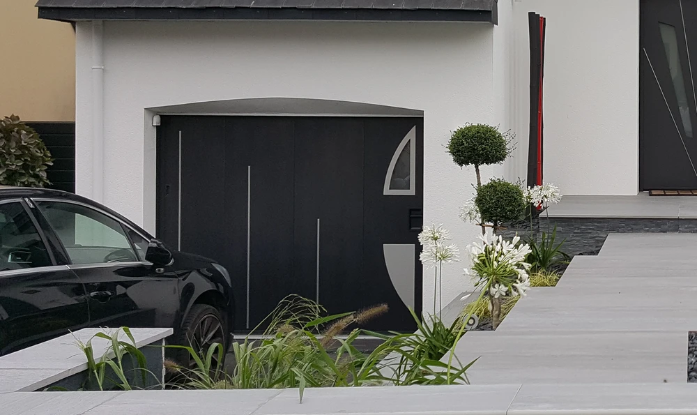 Portail coulissant moderne en aluminium gris anthracite installé devant une propriété résidentielle