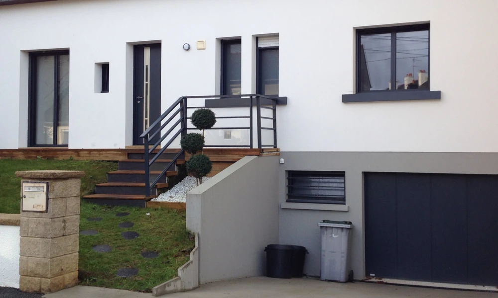 Extérieur résidentiel avec portail coulissant automatique noir installé entre murs beiges